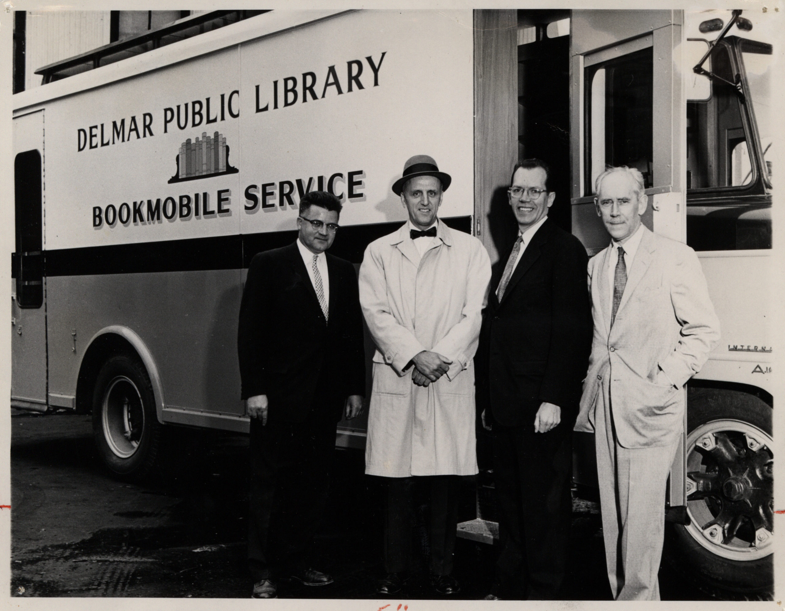 The Bookmobile Goes to Moscow: on the Finn Lines pier in Brooklyn with l. to. r. bookmobile builder Thomas F. Moroney, library board president Theodore Wenzl, John Mackenzie Cory of the American Library Association, and Thomas J. McLaughlin, head of the Combined Book Exhibit delegation (Publisher’s Weekly 5.25.59, photo by Robert Berenson)